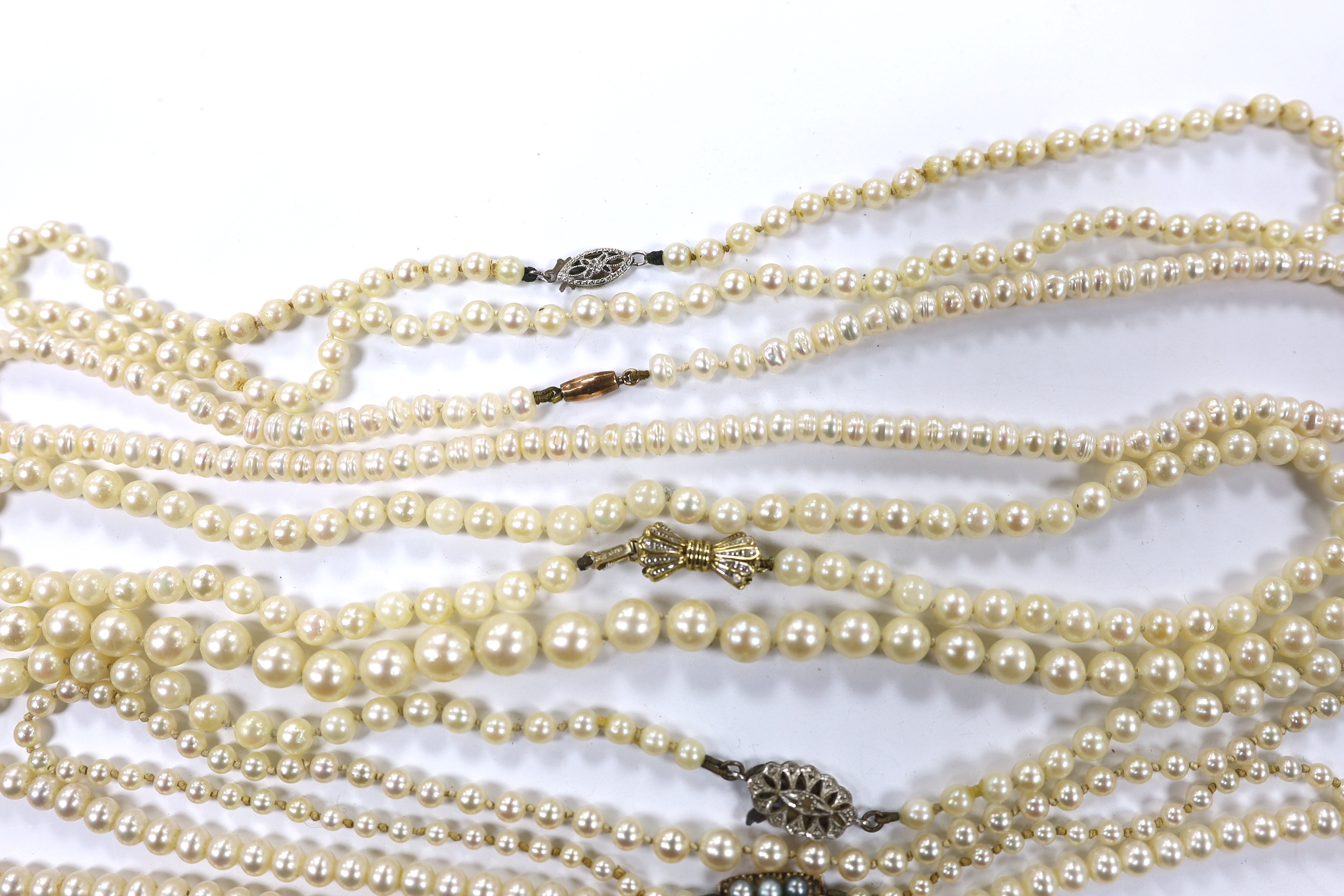 A collection of nine assorted cultured pearl necklaces with 9ct or yellow metal clasps.